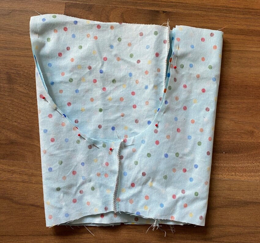 One shorts leg being tucked into the other, right sides together, to align the U-shaped crotch seam before sewing