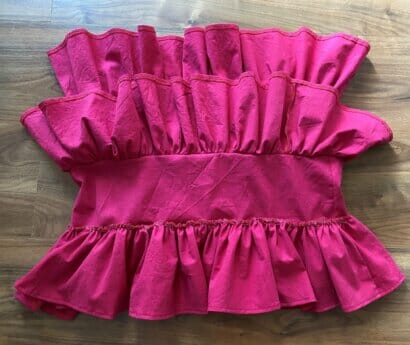 Three layers of fabric ruffles pinned and sewn onto the inner connector piece, showing the tiered structure