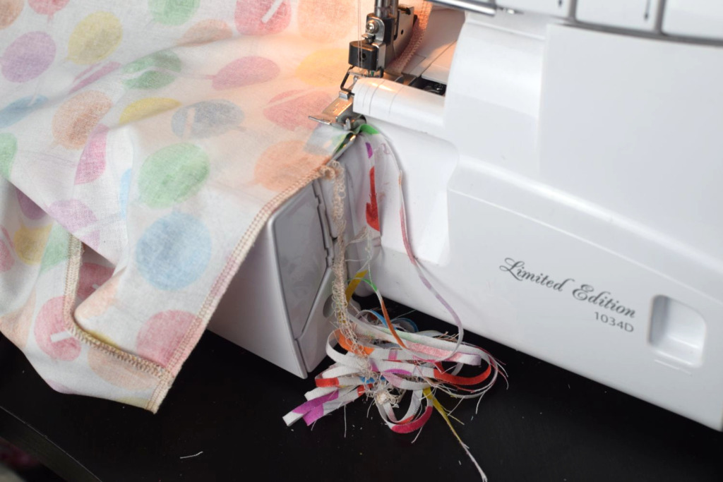 serger cutting the raw edge of the fabric