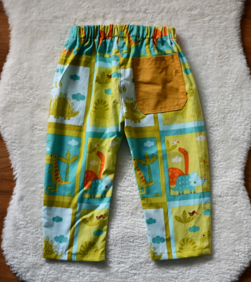 The back view of DIY kids' pants showing a contrast solid-colored pocketson a printed fabric base