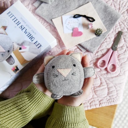 kid's hands holding a hand-sewn felt cat toy