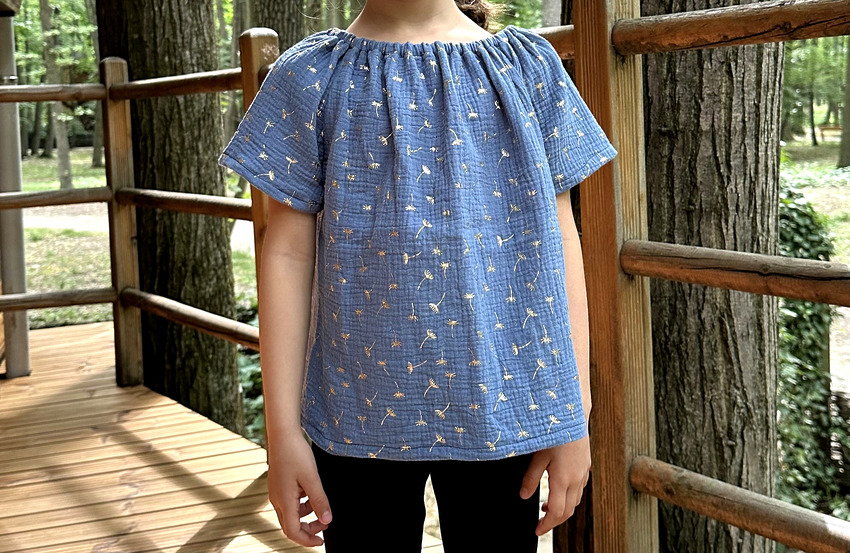A DIY navy blue peasant top with gold flower patterns and ruffled neckline