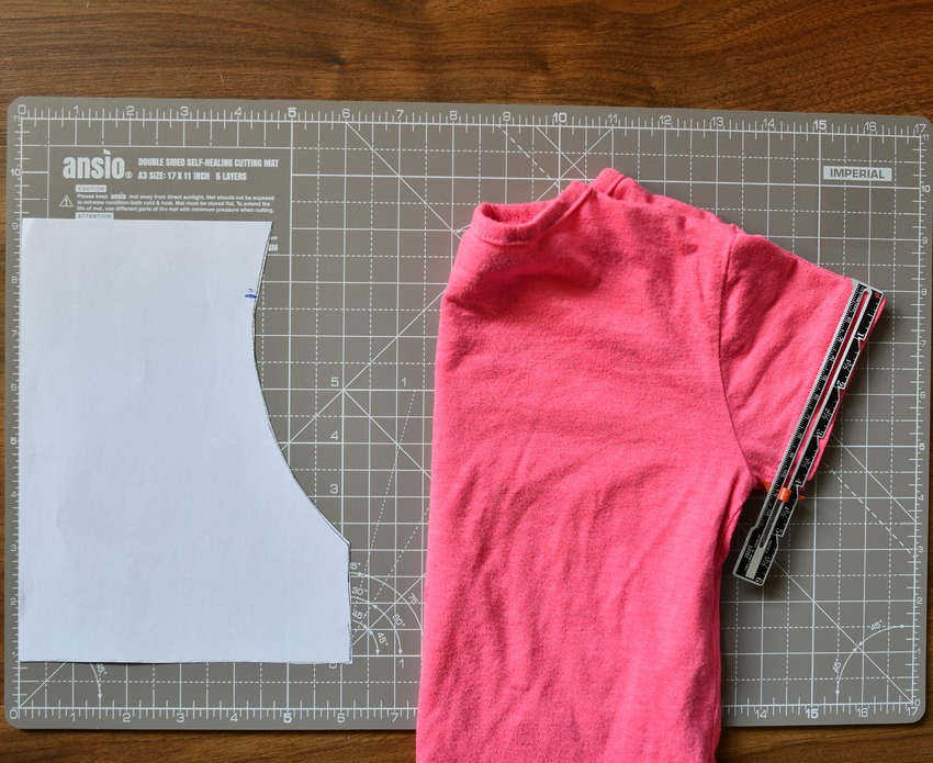 A folded girl's short sleeve t-shirt used as a template for drafting a DIY peasant top pattern