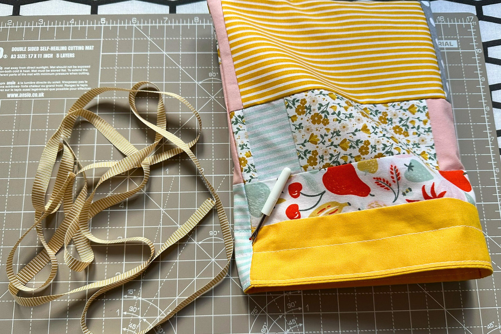 Using a seam ripper to carefully snip the side seam stitches to create an opening for the drawstring cord
