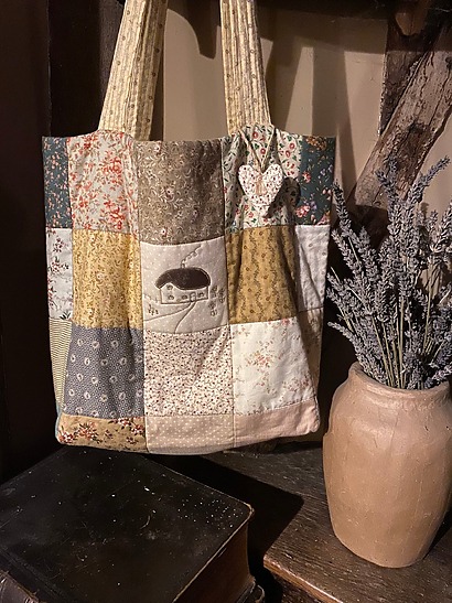 Patchworksathome Patchwork Tote: A rustic "make do and mend" style tote bag made from fabric squares, featuring a charming cottage applique design on the front