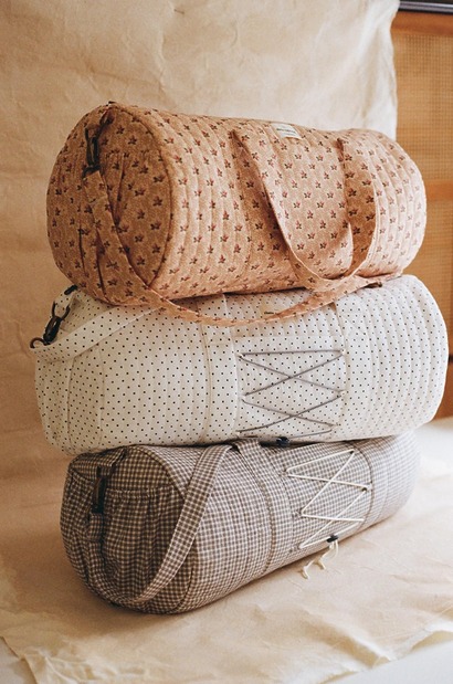 structured, padded quilted kit bags in a soft floral fabric with an adjustable shoulder strap and gathered side pockets