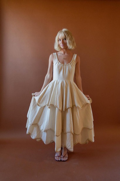 A romantic Millie dress with a scooped drawstring neckline and a unique tiered skirt featuring a decorative scalloped hem