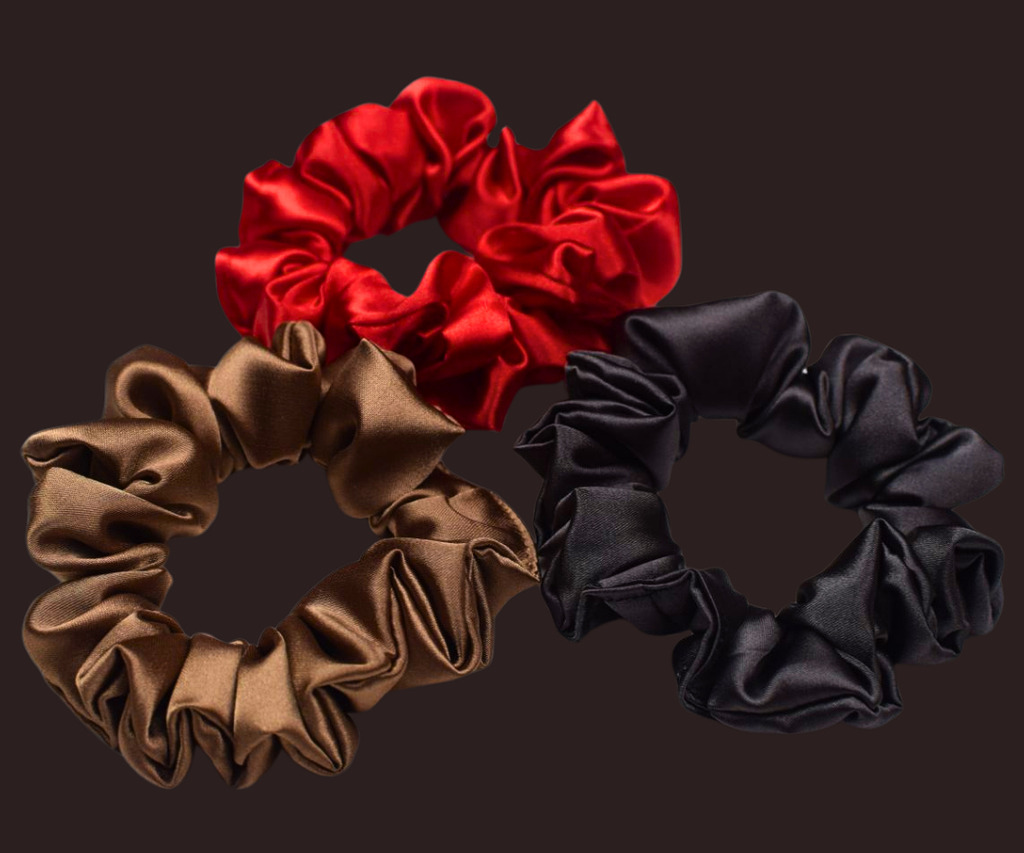 three handmade satin scrunchies in brown, red, and black fabrics